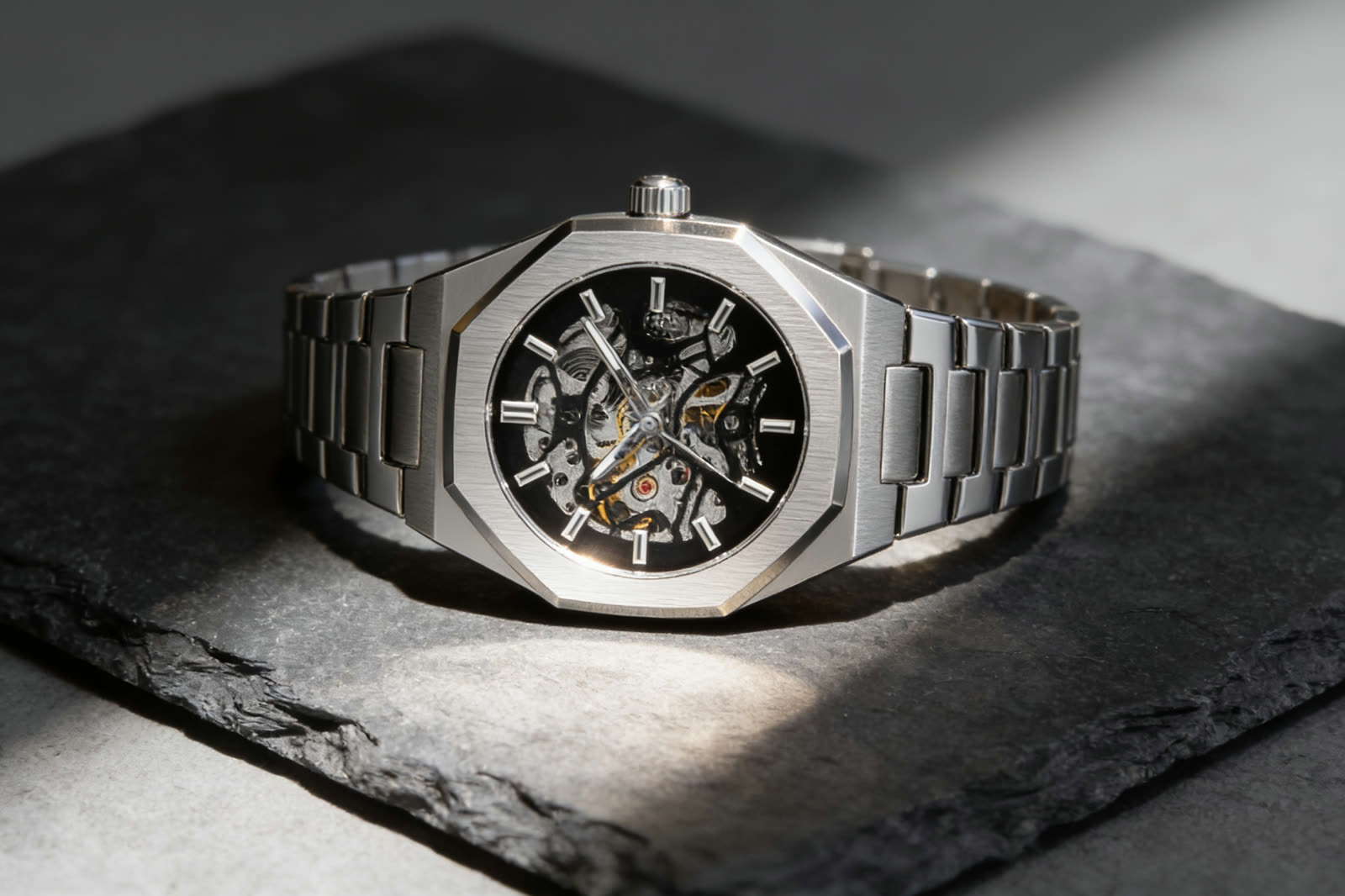 Close view of an open skeleton dial with visible gears and bridges inside a steel octagonal case
