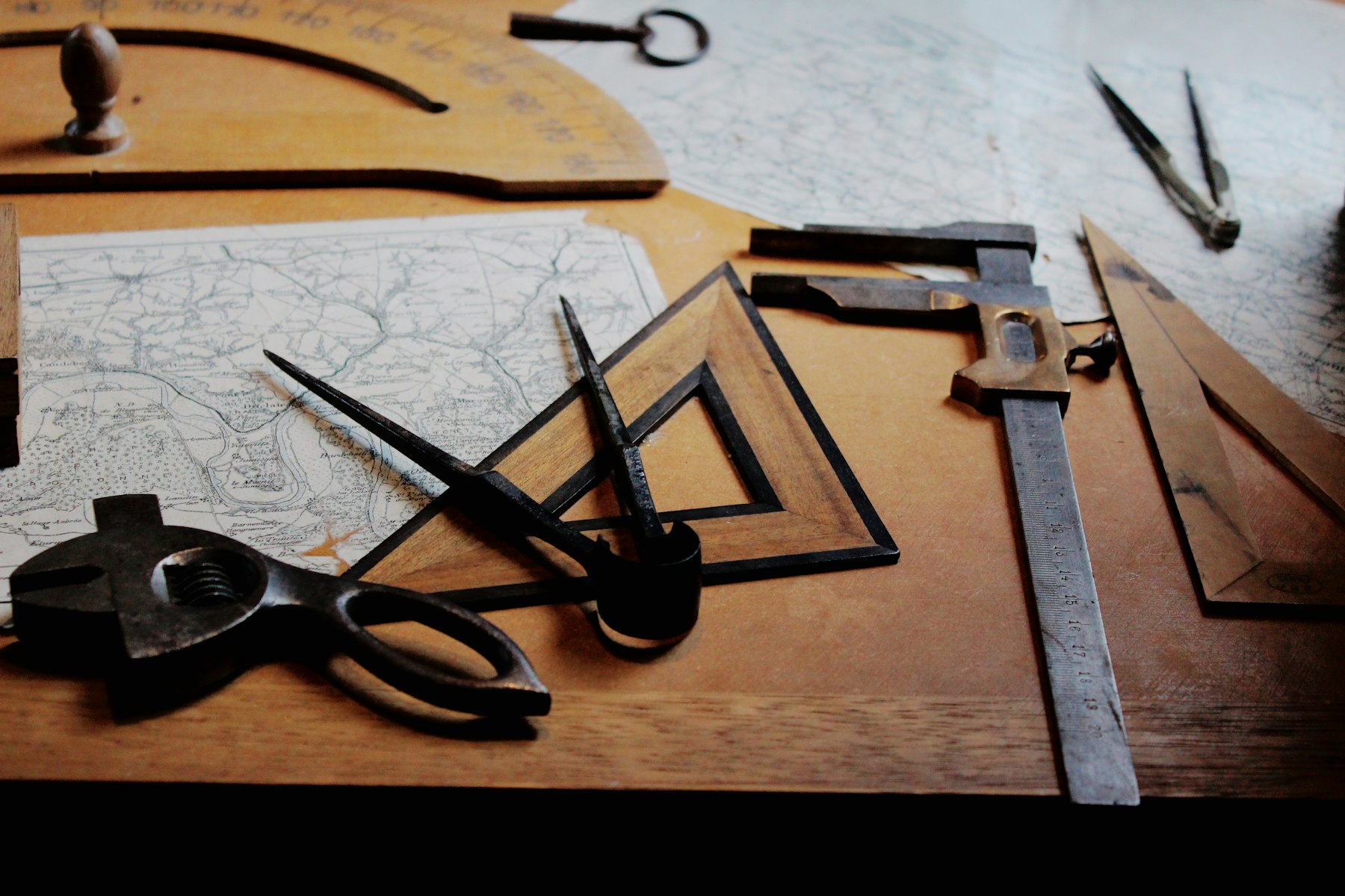Drafting tools, calipers and set squares lying on technical drawings